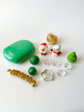 Load image into Gallery viewer, Collection of Christmas-themed decorative items including a green play dough, small Santa Claus figurine, snowman figurine, and decorative crystals on a white background.